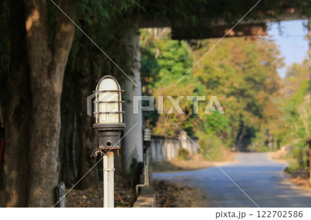 A compact street lamp mounted on a short metal pole provides essential lighting for roads and pathways. It enhances safety, visibility, and security in urban. A compact street lamp mounted on a short metal pole provides essential lighting for roads and pathways. It enhances safety, visibility, and security in urban. 122702586