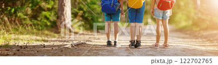 Three children standing along a path in a summer forest. Three children standing along a path in a summer forest. 122702765