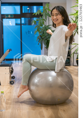 バランスボールでエクササイズする若い女性 バランスボールでエクササイズする若い女性 122703463
