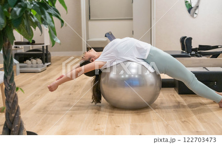 バランスボールでエクササイズする若い女性 バランスボールでエクササイズする若い女性 122703473