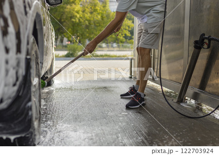the man herself at the car wash washes the car with a brush the man herself at the car wash washes the car with a brush 122703924