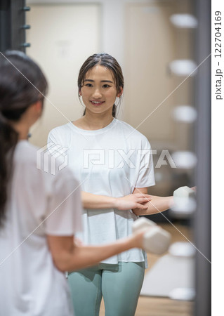 ダンベルを持ってトレーニングする若い女性 ダンベルを持ってトレーニングする若い女性 122704169