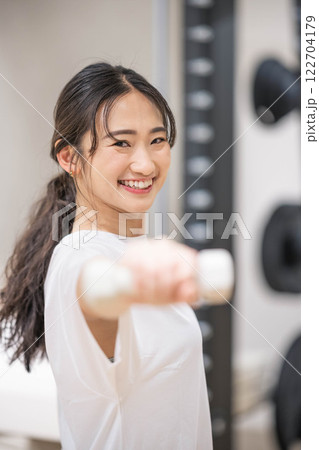 ダンベルを持ってトレーニングする若い女性 ダンベルを持ってトレーニングする若い女性 122704179