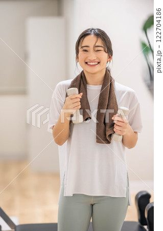 ダンベルを持ってトレーニングする若い女性 122704186