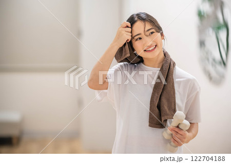 ダンベルを持ってトレーニングする若い女性 ダンベルを持ってトレーニングする若い女性 122704188