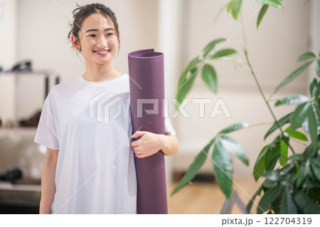 ヨガマットを持って笑う若い女性 ヨガマットを持って笑う若い女性 122704319
