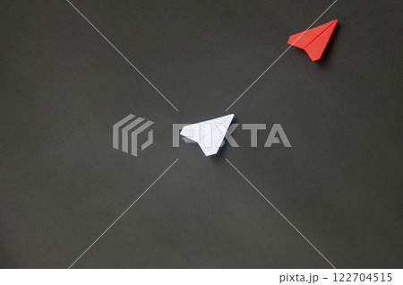 Top view of red paper airplane origami leading white airplane on blue dark background. Leadership skills concept Top view of red paper airplane origami leading white airplane on blue dark background. Leadership skills concept 122704515