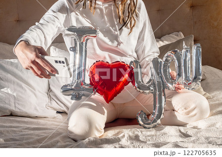 Heart balloon video call or selfie at sunlit home. 122705635