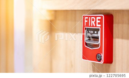 Red fire alarm switch mounted on wooden wall in the office interior Red fire alarm switch mounted on wooden wall in the office interior 122705695