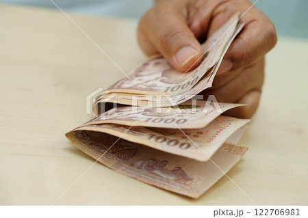 Asian woman counting Thai baht banknote money and holding in hand, investment economy, accounting business and banking. Asian woman counting Thai baht banknote money and holding in hand, investment economy, accounting business and banking. 122706981