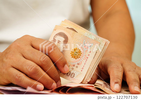 Asian woman counting Thai baht banknote money and holding in hand, investment economy, accounting business and banking. 122707130