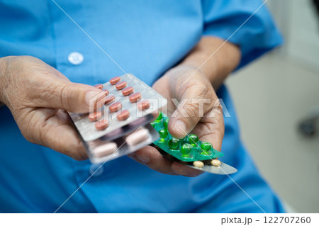 Asian elderly woman holding pill drug in hand, strong healthy medical concept. 122707260