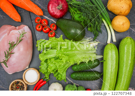 A lot of food on a dark background: turkey fillet with a sprig of rosemary, spices and salt in wooden bowls, herbs, vegetables and root vegetables. The concept of healthy and healthy nutrition, diet A lot of food on a dark background: turkey fillet with a sprig of rosemary, spices and salt in wooden bowls, herbs, vegetables and root vegetables. The concept of healthy and healthy nutrition, diet 122707348