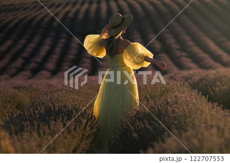 Woman Lavender Field Provence: Golden hour portrait of woman in yellow dress enjoying lavender field in Provence, France, summer. Woman Lavender Field Provence: Golden hour portrait of woman in yellow dress enjoying lavender field in Provence, France, summer. 122707553