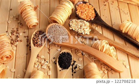 Wooden spoons with chia seeds, lentils, oats, and almonds, arranged on natural wooden surface, showcasing eco-conscious choices for healthy recipes using sustainable ingredients. Eco wooden spoons Wooden spoons with chia seeds, lentils, oats, and almonds, arranged on natural wooden surface, showcasing eco-conscious choices for healthy recipes using sustainable ingredients. Eco wooden spoons 122708218