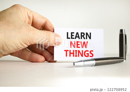 Learn new things symbol. Concept words Learn new things on beautiful white card. Beautiful white background. Businessman hand. Business motivational learn new things concept. Copy space. 122708952