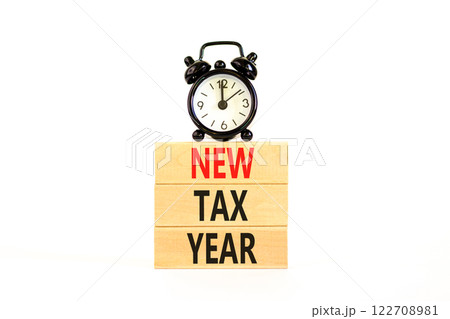New tax year symbol. Concept words New tax year on beautiful wooden blocks. Beautiful white background. Black alarm clock. Business new tax year concept. Copy space. 122708981