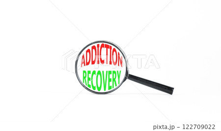 Addiction recovery symbol. Concept words Addiction recovery on beautiful black magnifying glass. Beautiful white table white background. Psychology addiction recovery concept. Copy space. 122709022