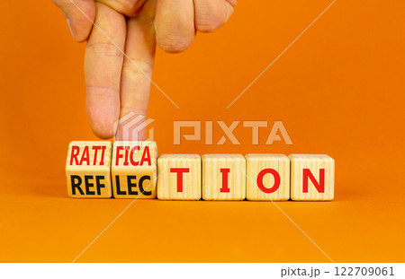 Ratification or reflection symbol. Concept words Ratification Reflection on wooden cubes. Beautiful orange background. Businessman hand. Business and ratification or reflection concept. Copy space. Ratification or reflection symbol. Concept words Ratification Reflection on wooden cubes. Beautiful orange background. Businessman hand. Business and ratification or reflection concept. Copy space. 122709061