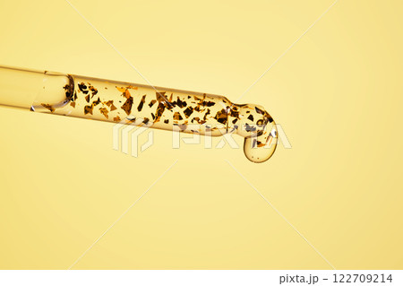 24 k gold facial serum in a pipette on a yellow background. 122709214