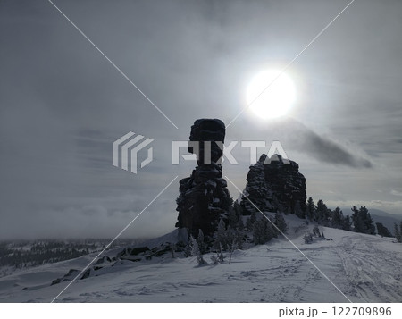 Winter landscape showcases towering rock formations under a bright sun in a snowy terrain 122709896