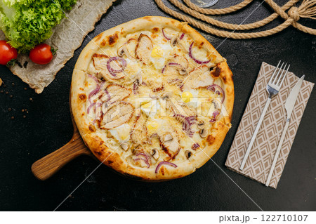 Gourmet pizza with grilled chicken, mushrooms, red onion, quail eggs, and parmesan 122710107