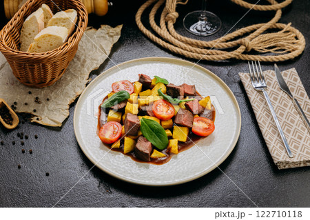 Gourmet beef cubes with roasted potatoes, cherry tomatoes and spinach with rich sauce and wine Gourmet beef cubes with roasted potatoes, cherry tomatoes and spinach with rich sauce and wine 122710118