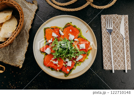 Roasted bell pepper carpaccio with arugula, feta cheese, pine nuts, and pesto, in gourmet style 122710148