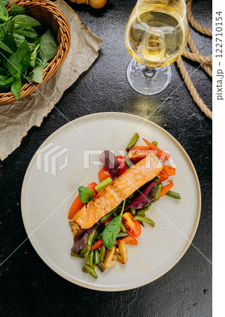 Grilled salmon fillet with fresh vegetables, served on a plate, elegant food presentation Grilled salmon fillet with fresh vegetables, served on a plate, elegant food presentation 122710154