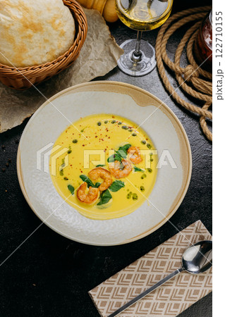 Creamy shrimp soup with spinach, garnished with chili flakes and herb oil, served in a gourmet style Creamy shrimp soup with spinach, garnished with chili flakes and herb oil, served in a gourmet style 122710155