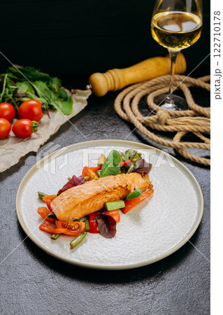 Grilled salmon fillet with fresh vegetables, served on a plate, elegant food presentation Grilled salmon fillet with fresh vegetables, served on a plate, elegant food presentation 122710178