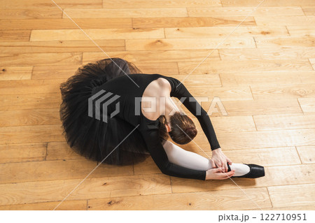 Young ballerina in tutu skirt stretching practicing ballet positions dancing on floor in dance class. Young classical dancer woman in dance studio. Ballet class training Ballet school concept Young ballerina in tutu skirt stretching practicing ballet positions dancing on floor in dance class. Young classical dancer woman in dance studio. Ballet class training Ballet school concept 122710951