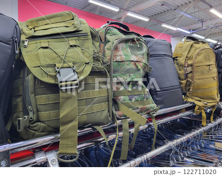 There are large backpacks in black and khaki on the shelf in the store. There are large backpacks in black and khaki on the shelf in the store. 122711020