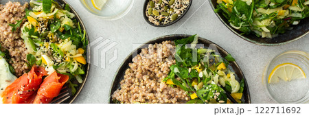 Buckwheat with fried egg and salmon fish, mix salad with fresh herbs and peppers Buckwheat with fried egg and salmon fish, mix salad with fresh herbs and peppers 122711692