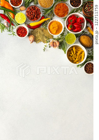 Colorful herbs and spices scattered across a gray surface, ideal for creating authentic and flavorful dishes, top view and copy space 122711759