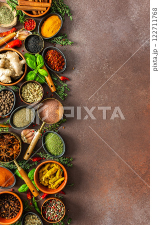 A harmonious mix of spices and herbs, bursting with colors and fragrances, spread on a warm brown background, evoking a sense of culinary artistry A harmonious mix of spices and herbs, bursting with colors and fragrances, spread on a warm brown background, evoking a sense of culinary artistry 122711768