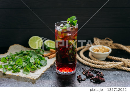 Refreshing hibiscus cocktail with lime, mint, and ice in a tall glass, summer and tropical vibes Refreshing hibiscus cocktail with lime, mint, and ice in a tall glass, summer and tropical vibes 122712022