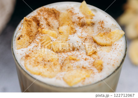 Creamy latte with whipped foam, dried apple slices, and cinnamon, served on a dark textured surface Creamy latte with whipped foam, dried apple slices, and cinnamon, served on a dark textured surface 122712067