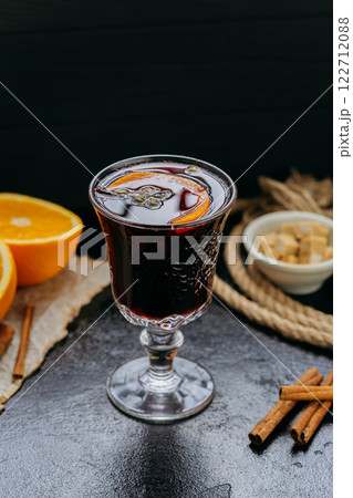 Mulled wine with orange and spices in elegant glass, creating a cozy and festive winter atmosphere 122712088