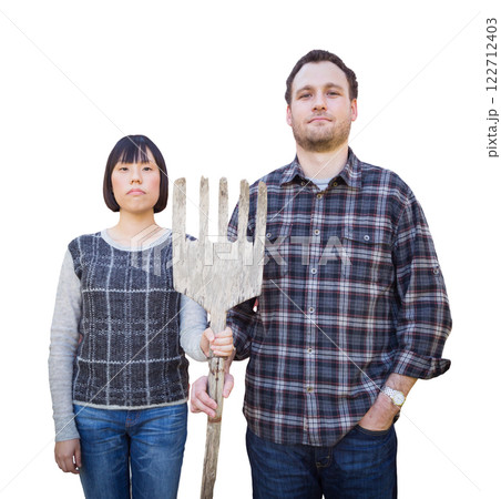 Mixed Race Chinese and Caucasian Couple Standing and Holding a Wooden Pitch Fork Isolated on a White Background. Mixed Race Chinese and Caucasian Couple Standing and Holding a Wooden Pitch Fork Isolated on a White Background. 122712403