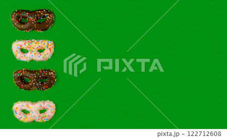 Flat lay of greeting card for birthday or carnival with cookies in the shape of a mask. Flat lay of greeting card for birthday or carnival with cookies in the shape of a mask. 122712608