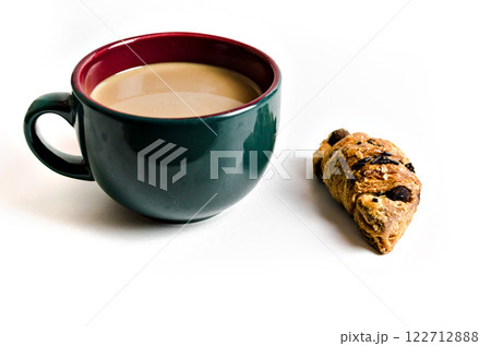 A cup of green latte coffee and a croissant on the table with a white background. Breakfast 122712888