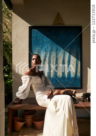 Androgynous person in white wedding dress, sunlit villa. Fluid identity. LGBTQ friendly bridal, inclusive style, gender-neutral attire. Luxury, art wall, modern design. Contemporary atmosphere. Androgynous person in white wedding dress, sunlit villa. Fluid identity. LGBTQ friendly bridal, inclusive style, gender-neutral attire. Luxury, art wall, modern design. Contemporary atmosphere. 122713918