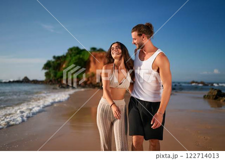 Affectionate adult couple stroll sandy beach at sunrise. Romantic duo walk near sea, childfree getaway. Laughing man, woman enjoy vacation, leisure stroll. Travel, summer, love, coast experience. Affectionate adult couple stroll sandy beach at sunrise. Romantic duo walk near sea, childfree getaway. Laughing man, woman enjoy vacation, leisure stroll. Travel, summer, love, coast experience. 122714013