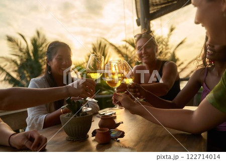 Diverse women cheers with wine glasses at sunset restaurant. Friends toast, enjoy drink, social meetup. Wine tasting, women club. Celebrate friendship. Relax, chat, smile outdoors. Sunset. Diverse women cheers with wine glasses at sunset restaurant. Friends toast, enjoy drink, social meetup. Wine tasting, women club. Celebrate friendship. Relax, chat, smile outdoors. Sunset. 122714014