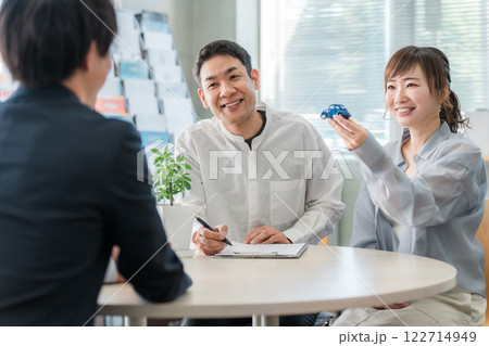 ショールーム・商談スペースで話を聞く夫婦と接客するビジネスマン ショールーム・商談スペースで話を聞く夫婦と接客するビジネスマン 122714949