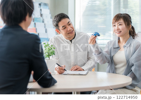 ショールーム・商談スペースで話を聞く夫婦と接客するビジネスマン ショールーム・商談スペースで話を聞く夫婦と接客するビジネスマン 122714950