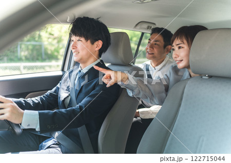 タクシーに乗り目的地を支持する乗客の夫婦 122715044