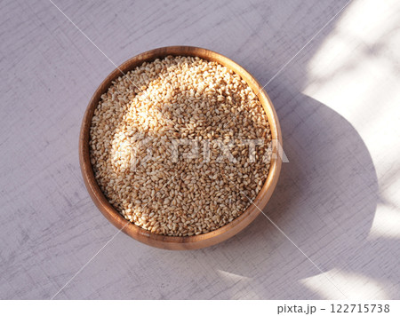 Top view of sesame in wooden bowl on white background. Copy space 122715738