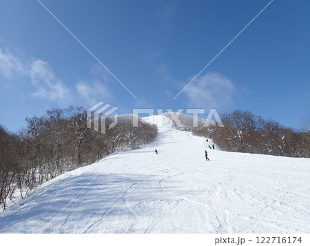 青空と山々に囲まれたスキー場のゲレンデ 122716174